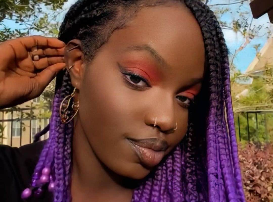 girl with black and purple box tribal braids with purple beads