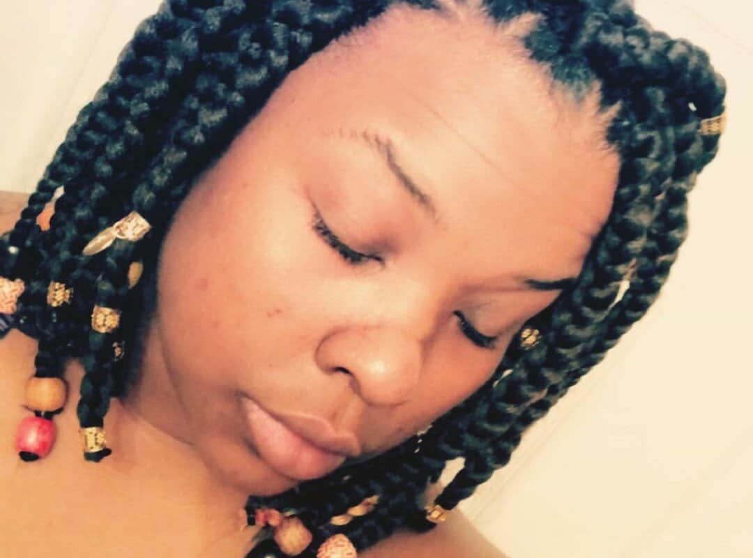 woman with black bob tribal braids with red and brown beads