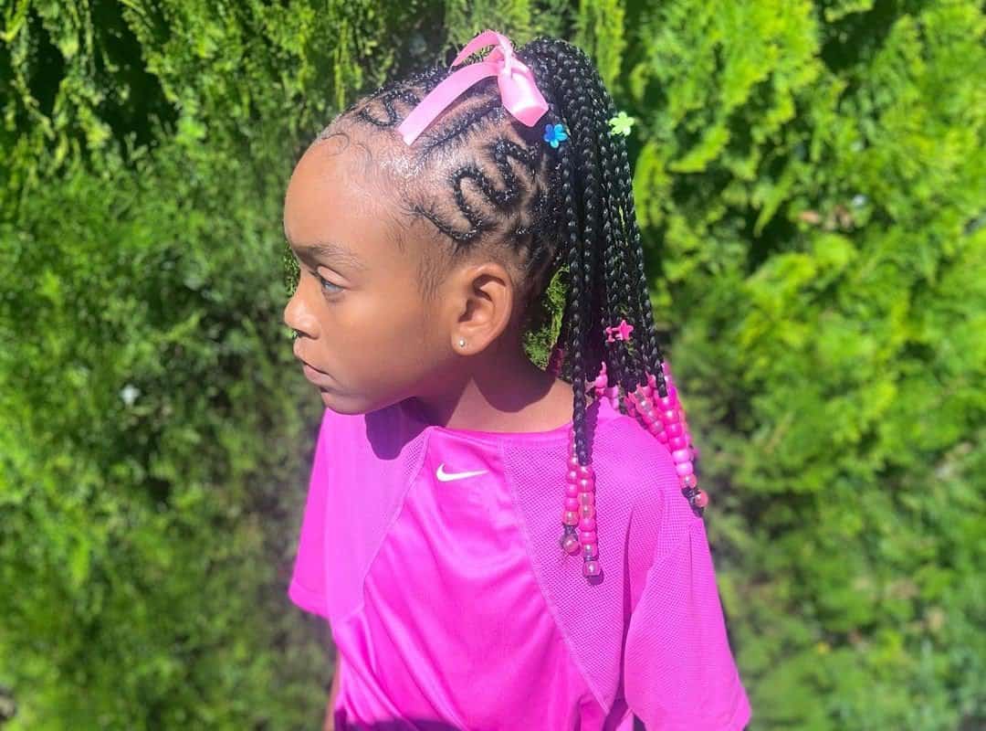 girl with black tribal braids with beads and pink ribbons