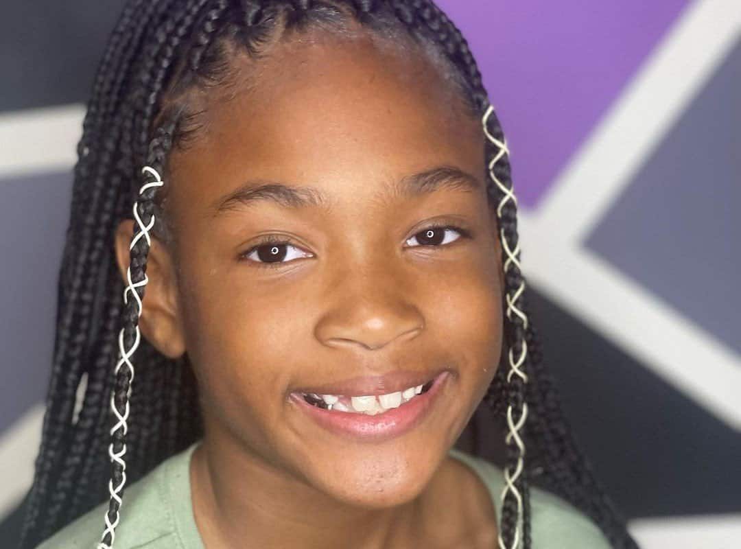 girl with black tribal braids with white ribbons