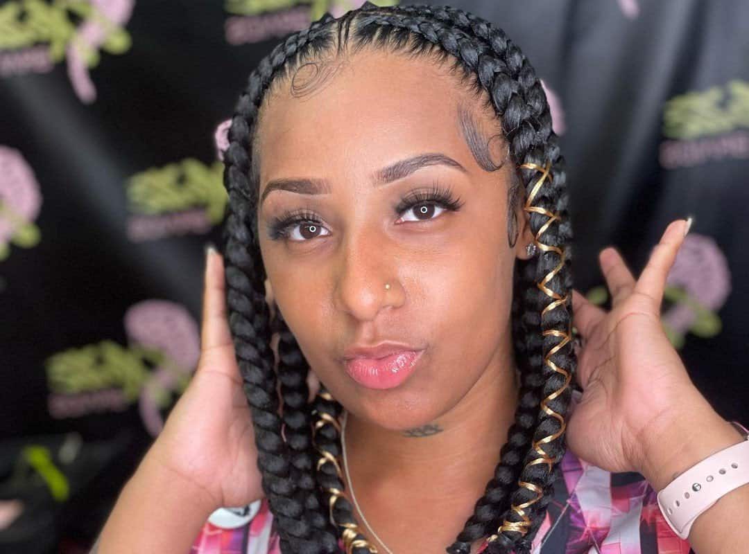 woman with dark black tribal braids with beads and golden ribbon