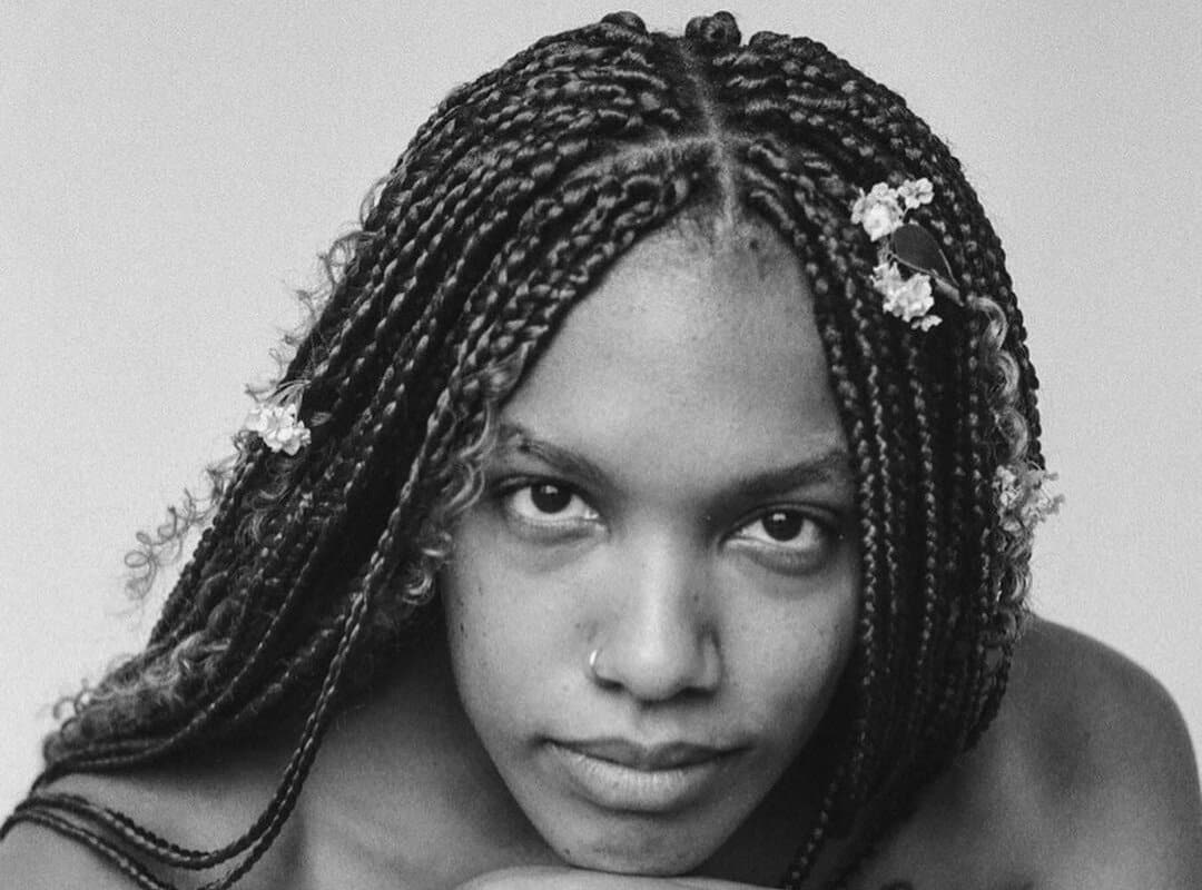 woman with dark tribal braids with flowers