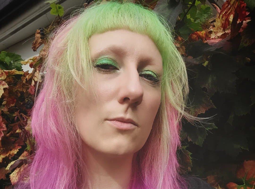woman with green-pink hair and baby bangs