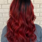 Red balayage hairstyle on black curly hair