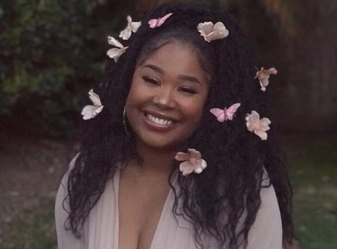 girl with black half up, half down hairstyle with flowers