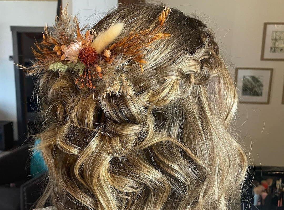 girl with brown half up, half down hairstyle with leaves and spikelets