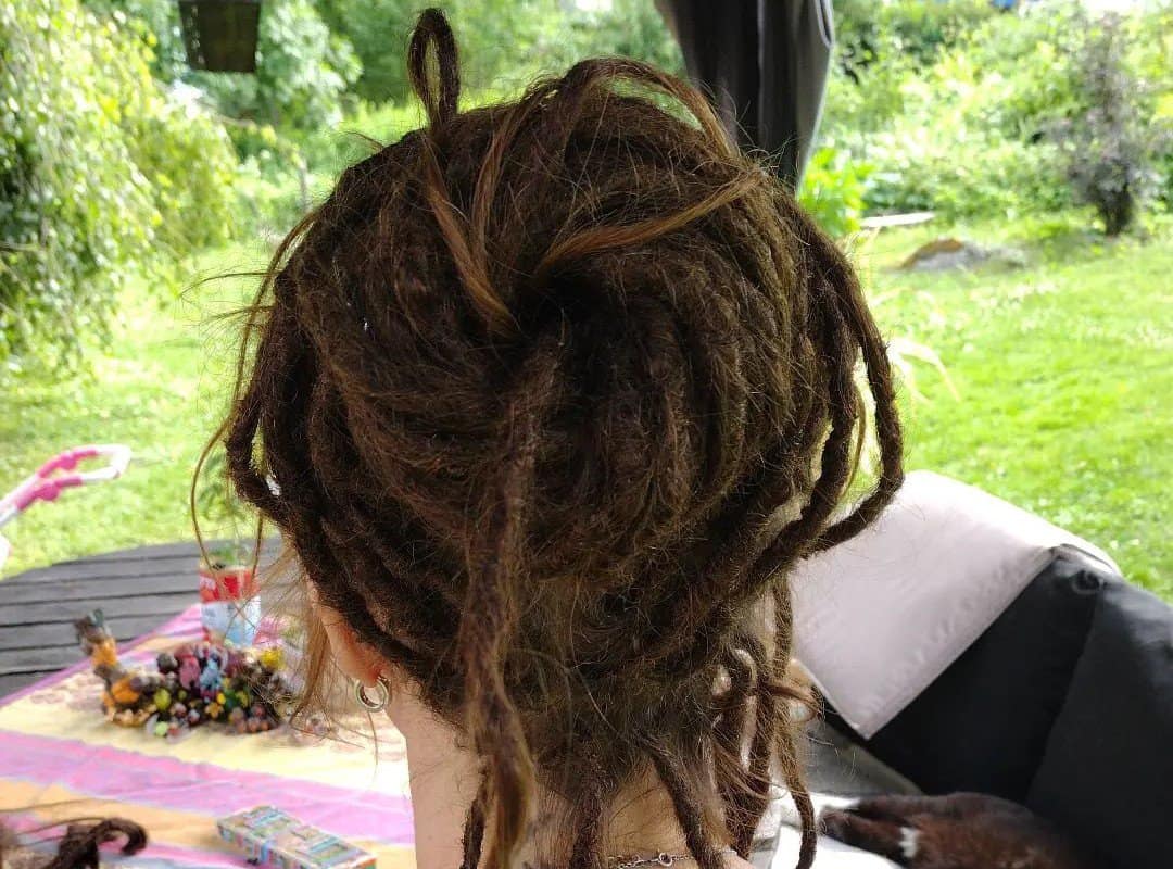 girl with brown hippie dyed dreads in messy bun